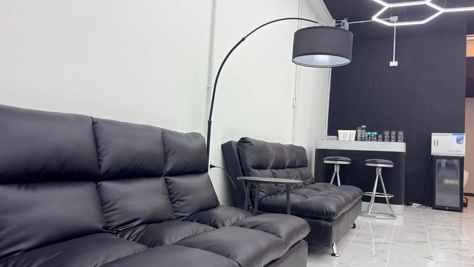 Wartebereich mit Ledersofas und Bogenlampe
