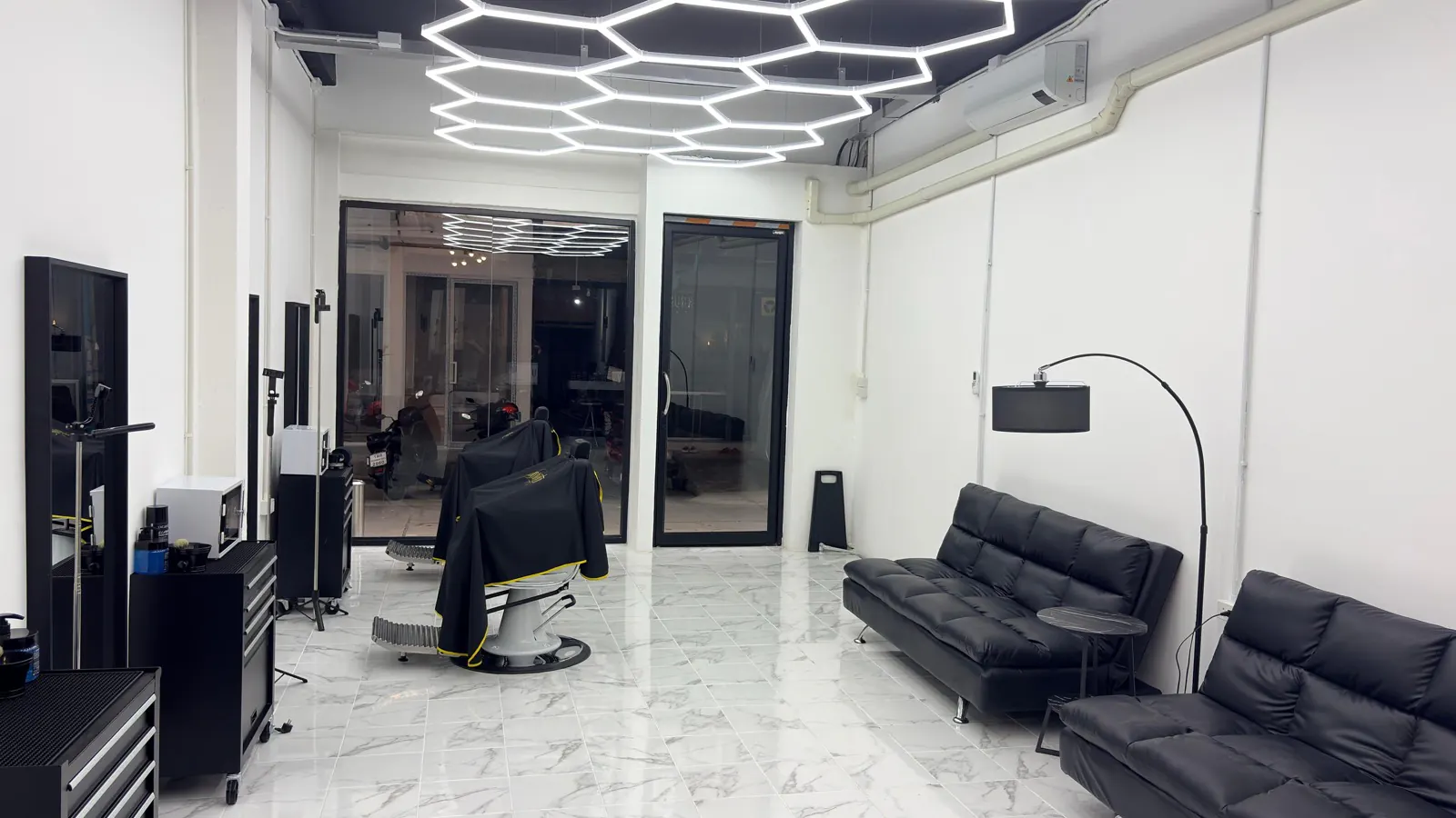 Blick in den Shop mit Barberstuhl und Lounge-Sofas